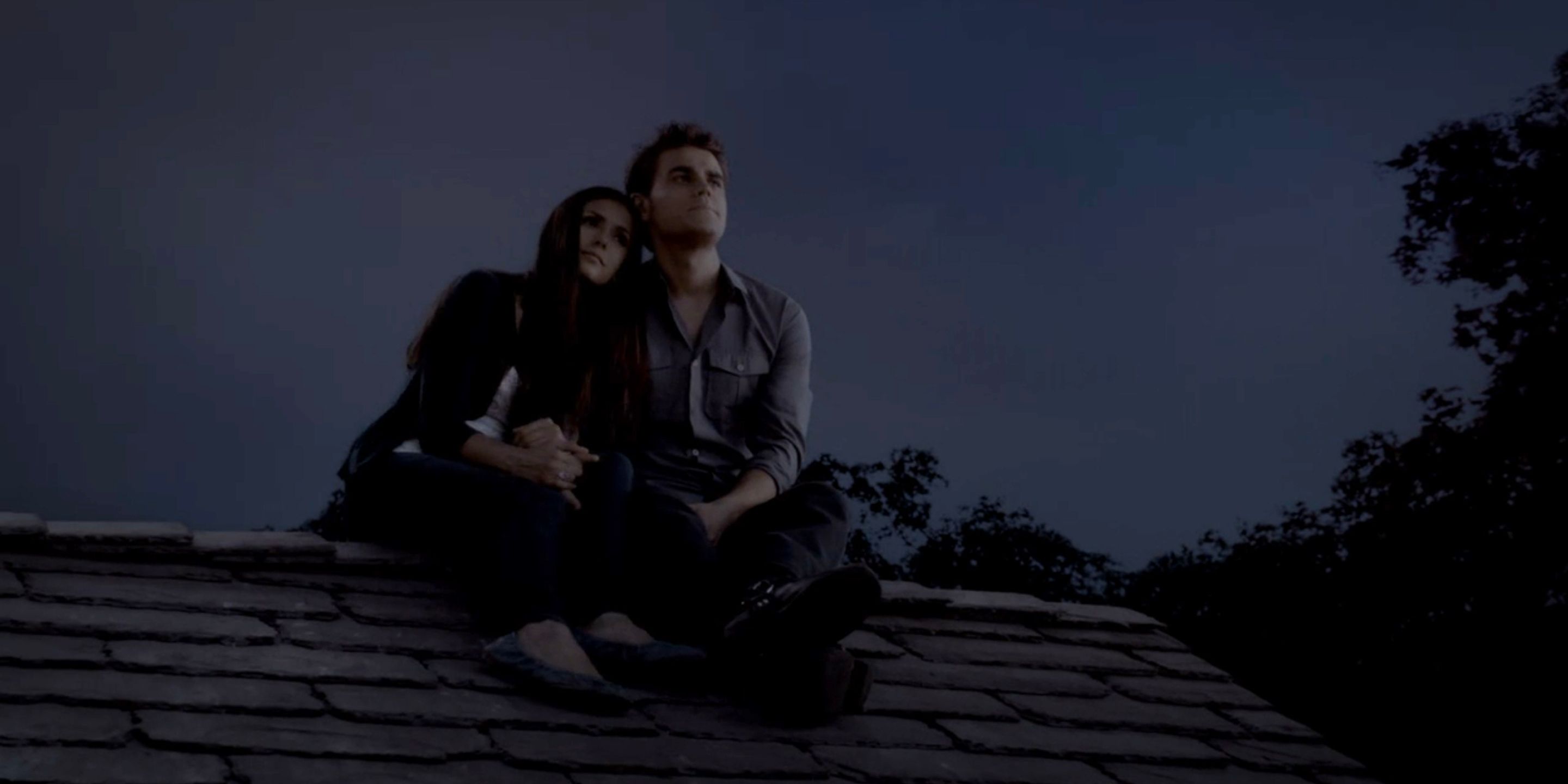 Stefan and Elena cuddle on the roof in The Vampire Diaries.
