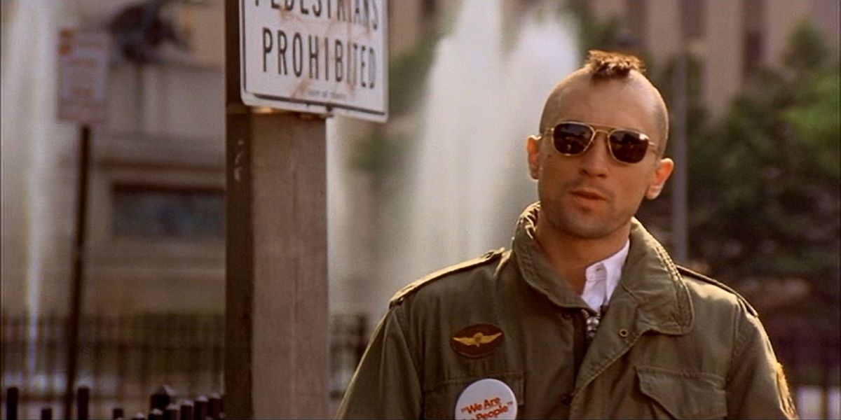 Robert De Niro in the 1976 movie Taxi Driver. walking down a NYC street with mohawk