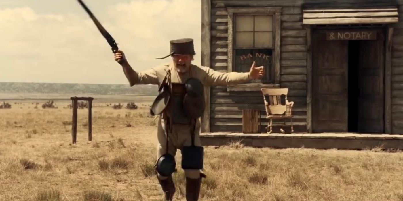 The bank teller coming out with his arms spread, holding a gun in The Ballad of Buster Scruggs