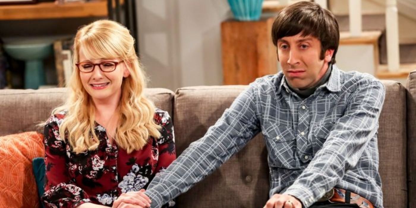 Bernadette and Howard crying on their couch in The Big Bang Theory