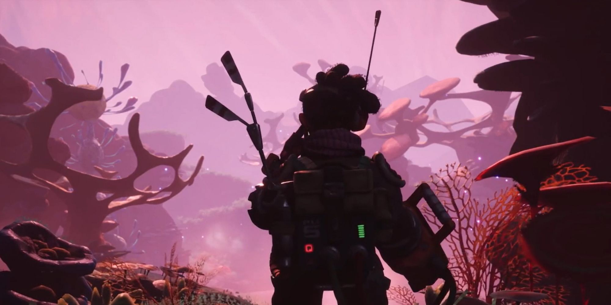 The protagonist with his back towards the viewer, facing an aliend landscape in the trailer for the game, The Gunk