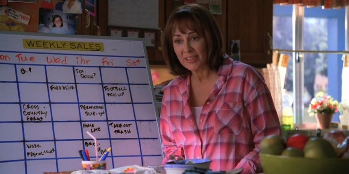 Frankie standing with her whiteboard schedule in The Middle.
