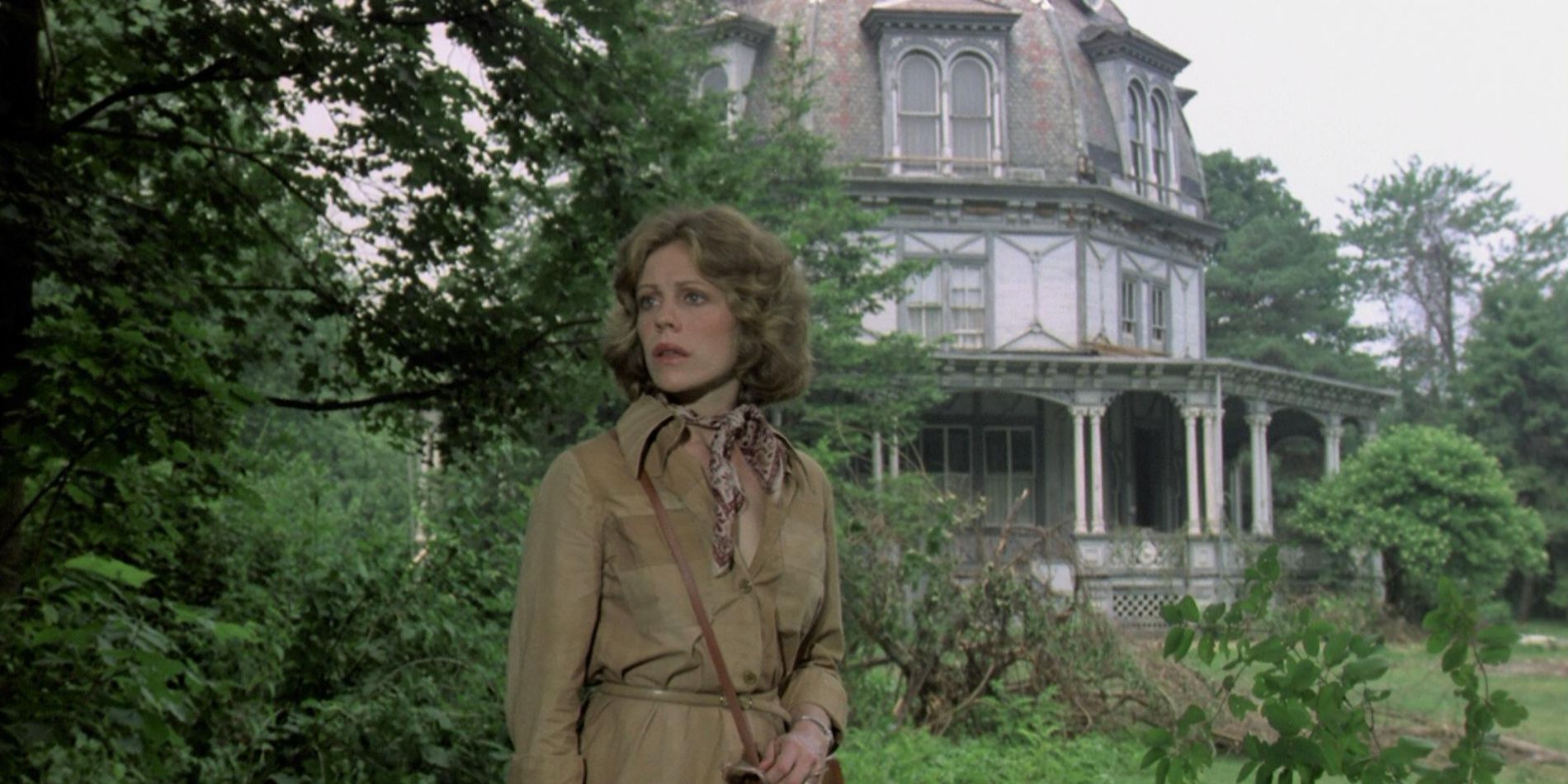 Lauren stands outside a haunted mansion in the 1981 film The Nesting.