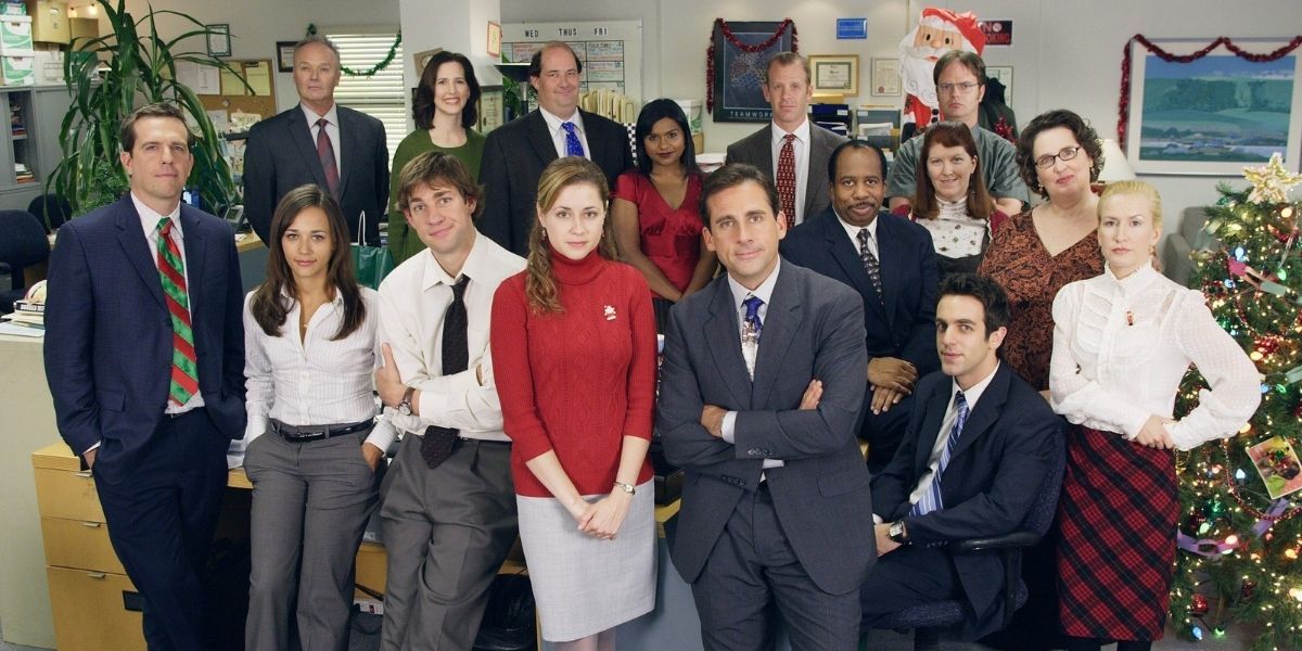The Office cast pose in front of a Christmas tree.
