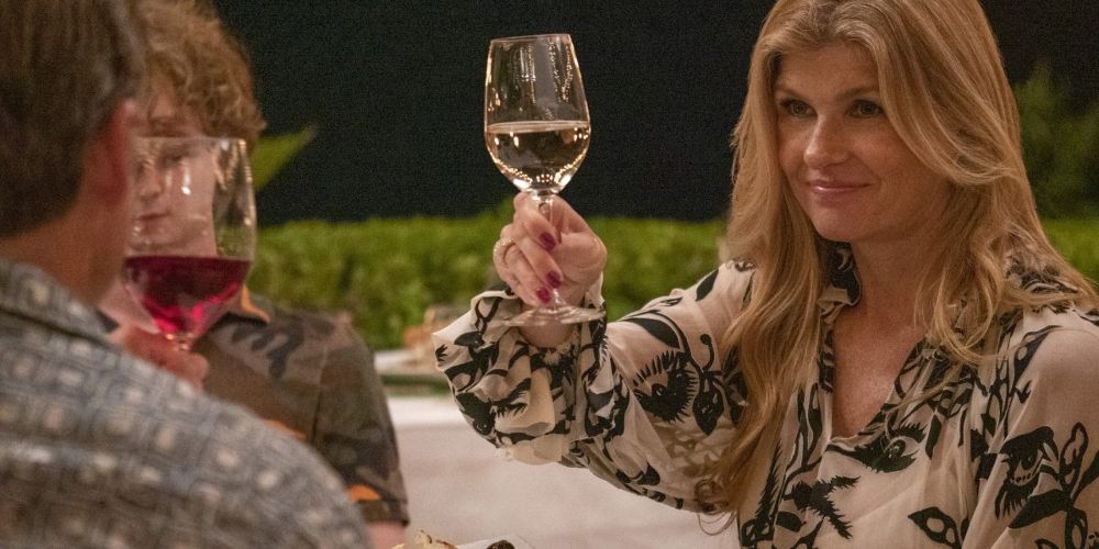 Nicole toasts her wine glass at dinner in The White Lotus