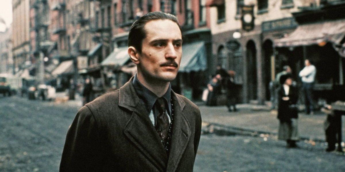 Vito Corleone walking on a street in a still from The Godfather Part II