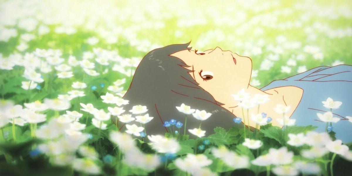 The mother from Wolf Children in a field of flowers looking up.