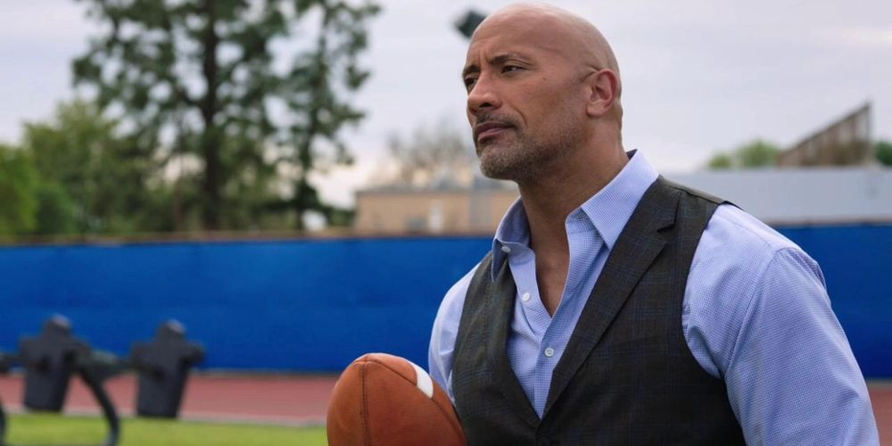 Spencer holds a football on the practice field in Ballers
