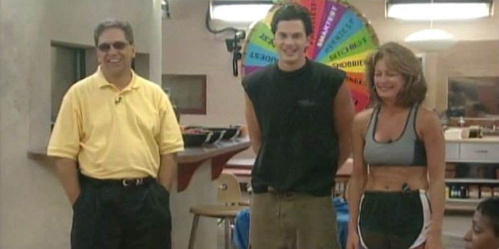Kent holds hands in his pockets by the color wheel in Big Brother 