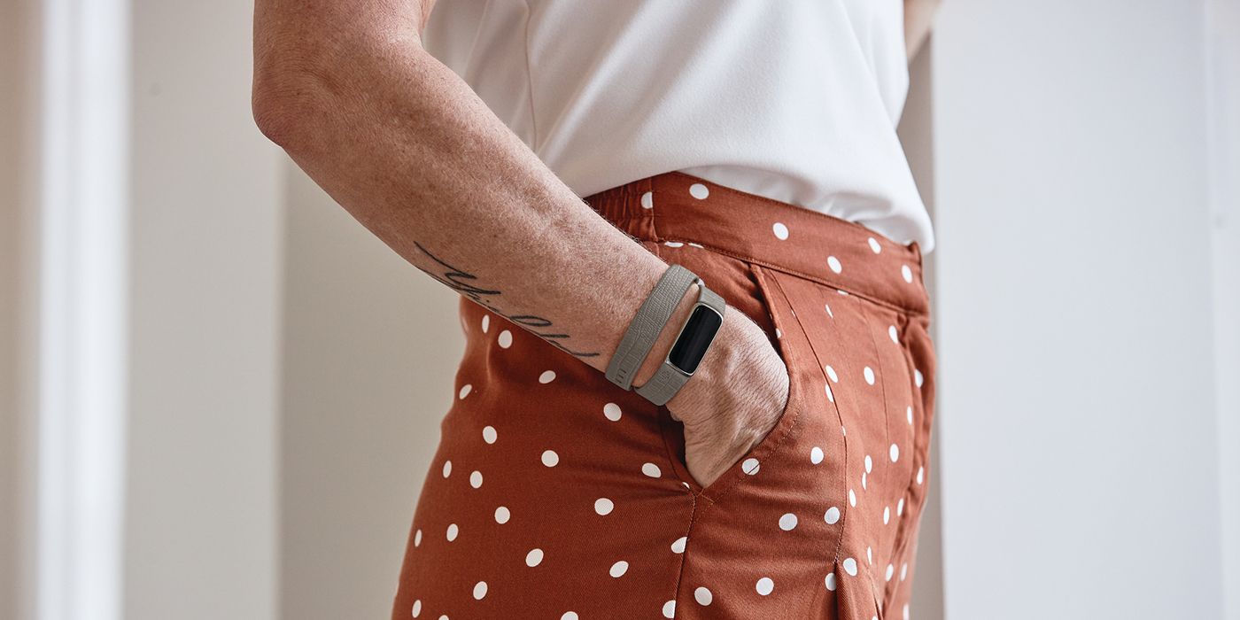 Fitbit Luxe on a woman's arm, with her hand in her pocket.
