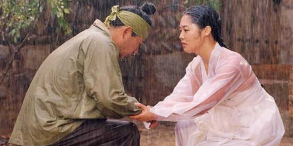 Hur Jun holds hand of a villager in the rain in Hur Jun.