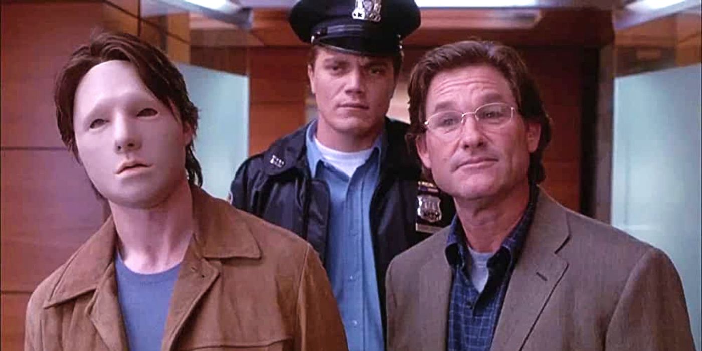 Kurt Russel and Tom Cruise with a white mask stand next to each other in Vanilla sky, michael shannon stands behind them in a police uniform
