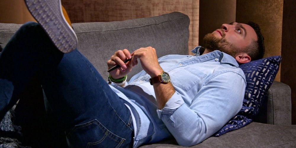 Mark Cuevas lays on the couch in agony in Love is Blind Season 1