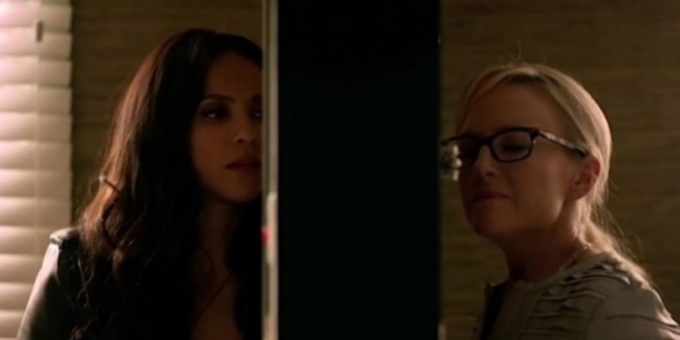Linda and Maze from Lucifer standing at opposite sides of a door, looking longing.