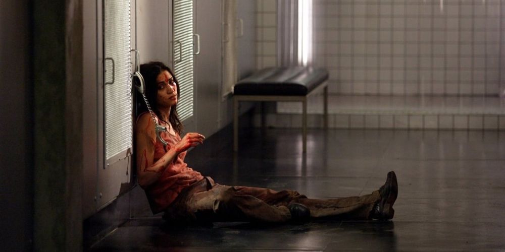 Lucie sits while handcuffed and covered in blood in Martyrs