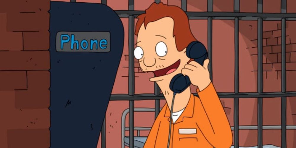 Mickey smiles while chatting on a prison telephone in Bob's Burgers