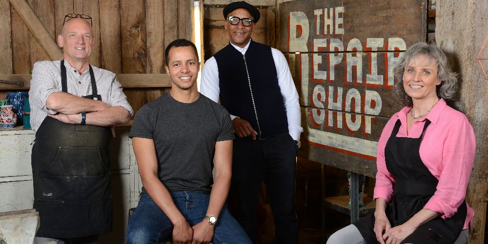 The cast of the Repair Shop pose in front of show logo for promo image