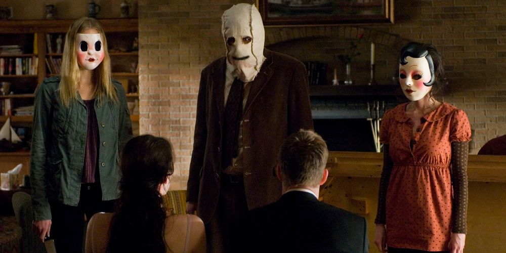 Kristen and James are tied up and tormented in their cabin by three masked intruders in The Strangers
