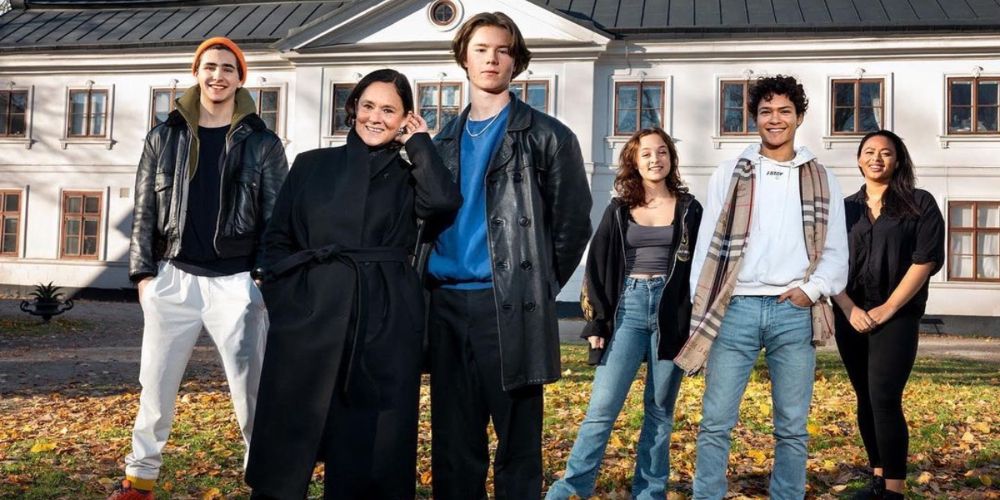 Ensemble cast photo for Netflix's Young Royals standing side by side and smiling.