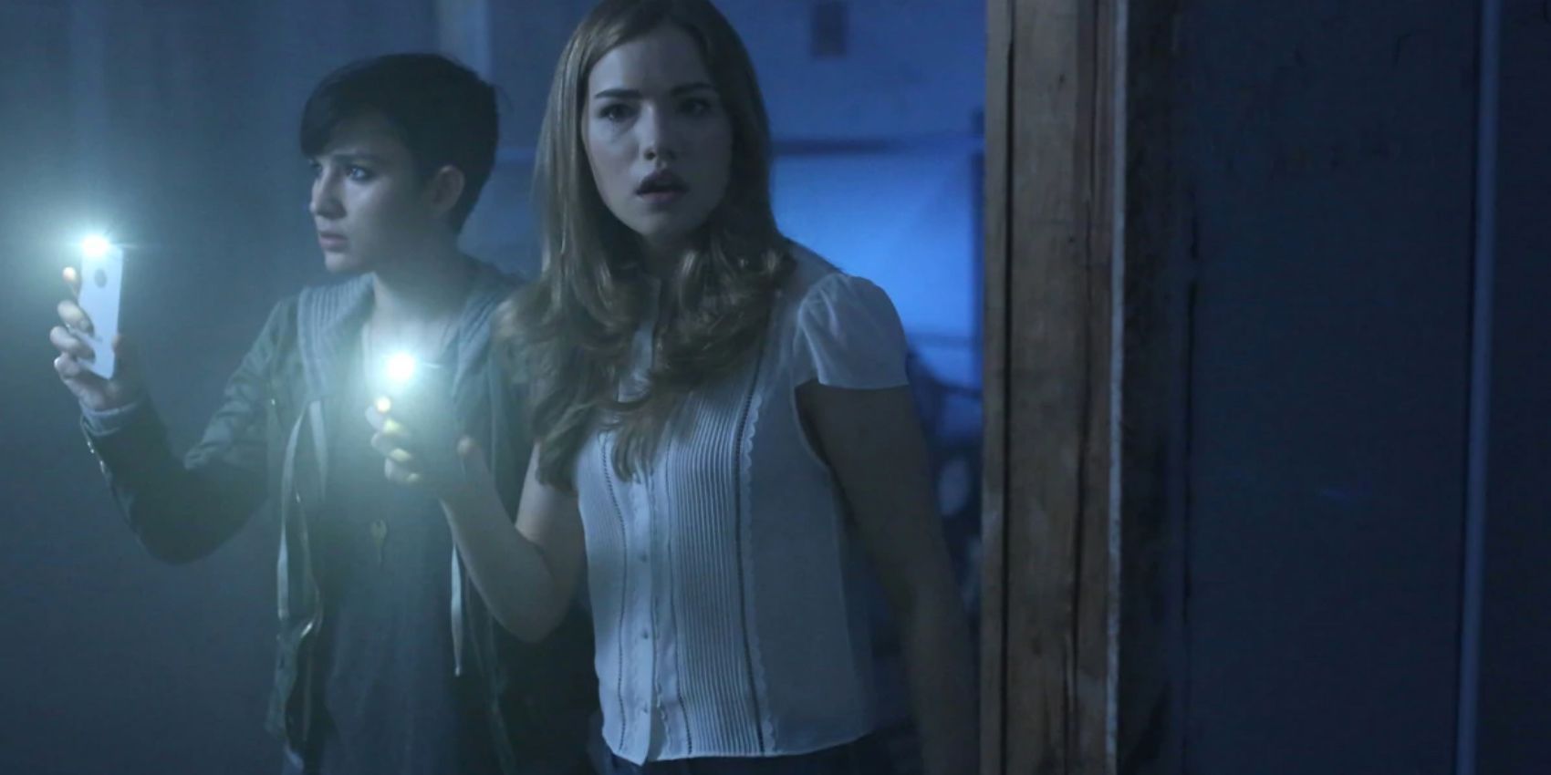 Audrey and Emma use their phones to light a path in the Scream episode The Orphanage
