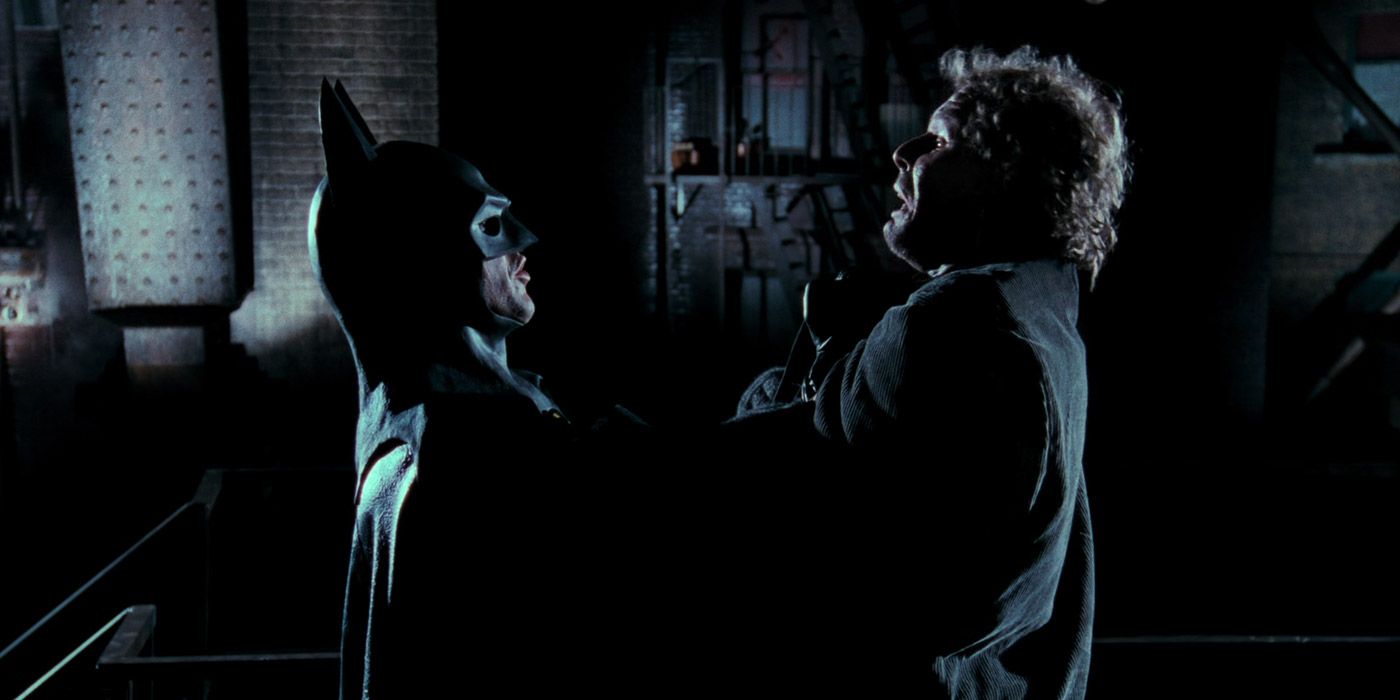 Batman suspends a thug over a rooftop in 1989's Batman