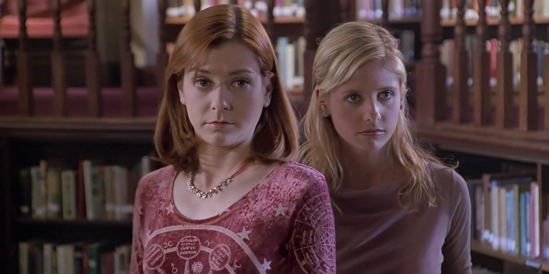 Willow and Buffy stand next to each other in the library in Buffy the Vampire Slayer