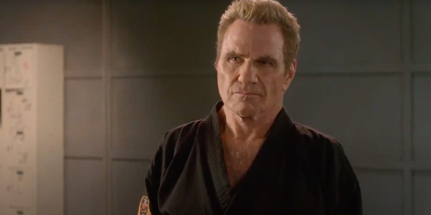 John Kreese standing with his black dojo, looking angry in a scene from Cobra Kai.
