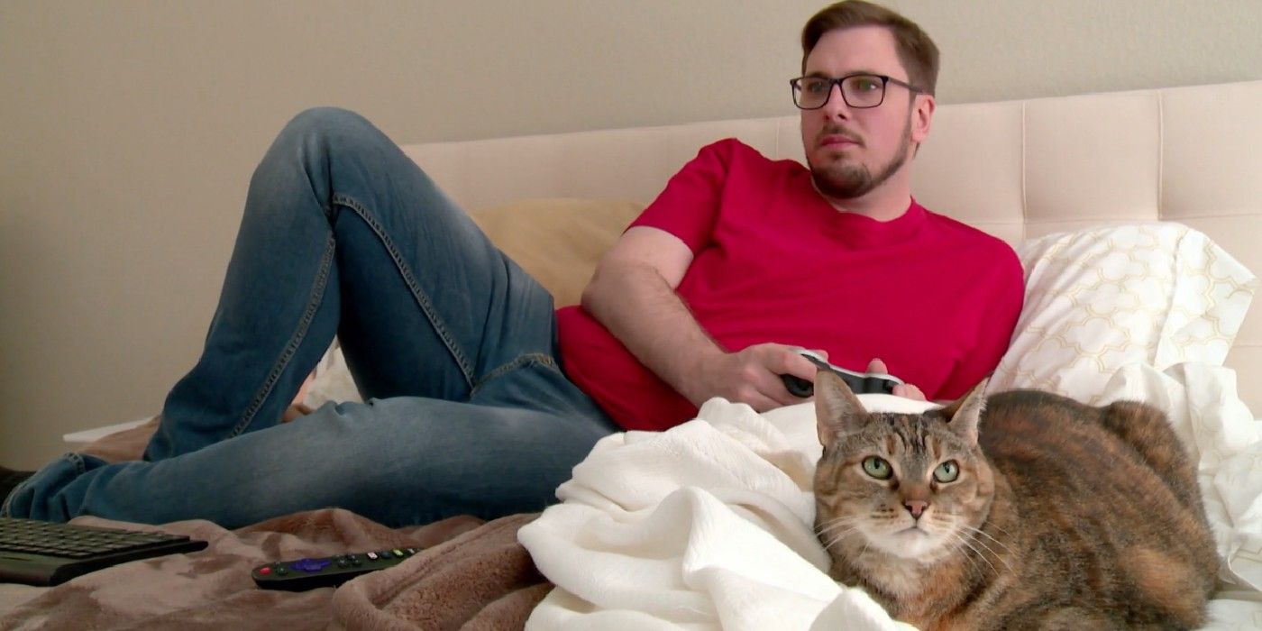 Colt Johnson laying on bed with cat in 90 Day Fiance