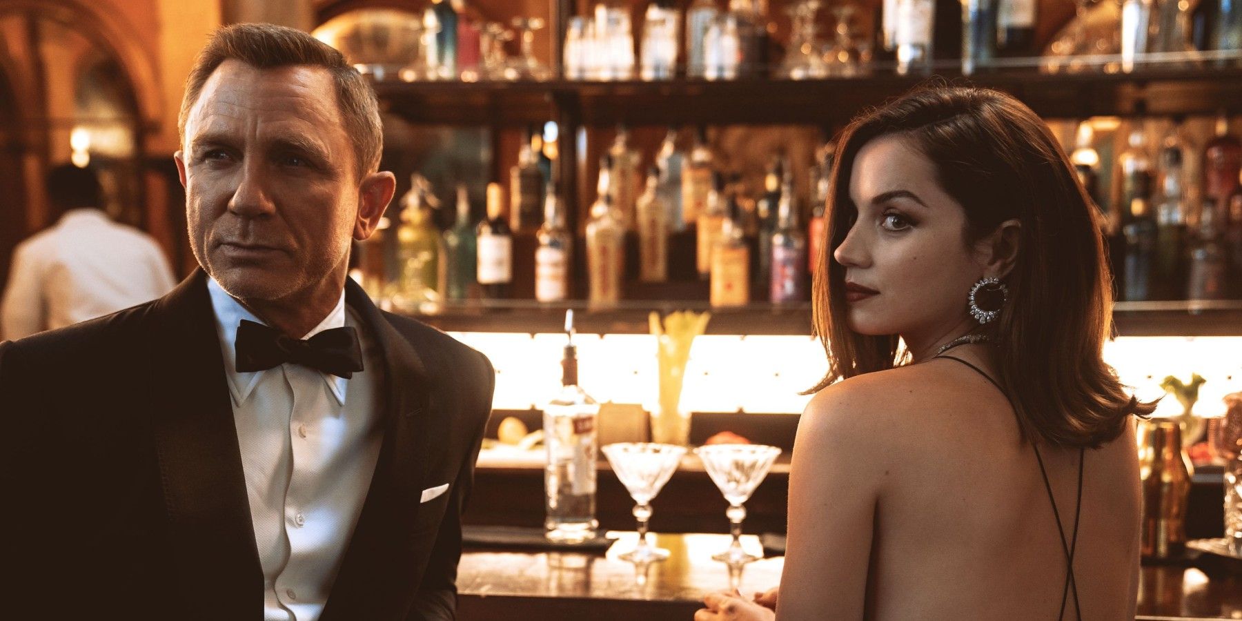 Daniel Craig and Ana de Armas standing at a bar in No Time to Die