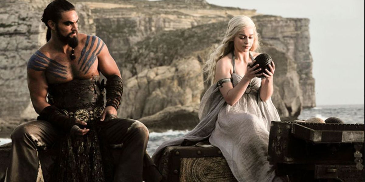 Drogo and Daenerys at their wedding celebration as she holds up a dragon egg in Game of Thrones