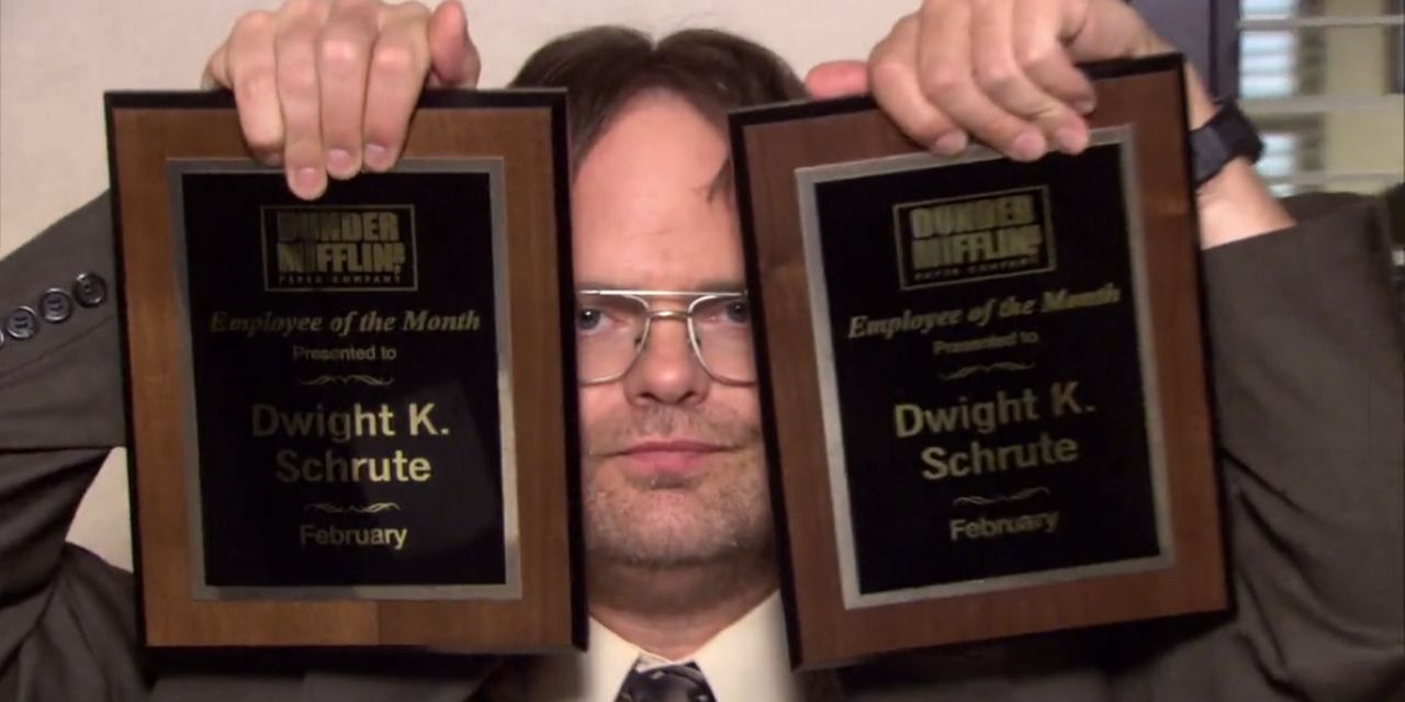 Dwight holds up his Employee of the Month awards in The Office.