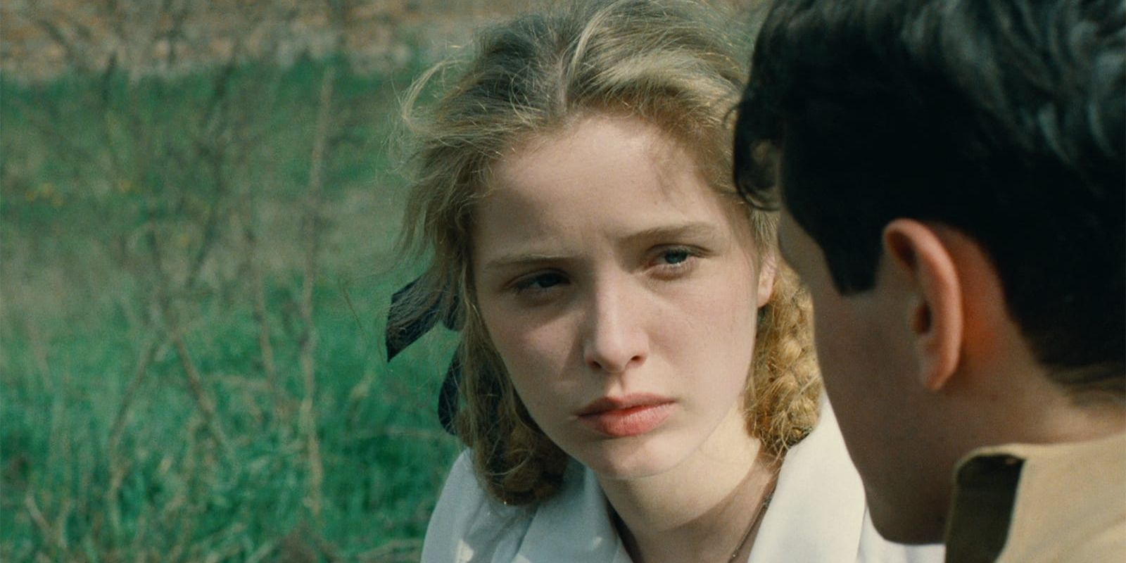 Julie Delpy looks at her lover in a field of grass in Europa Europa.