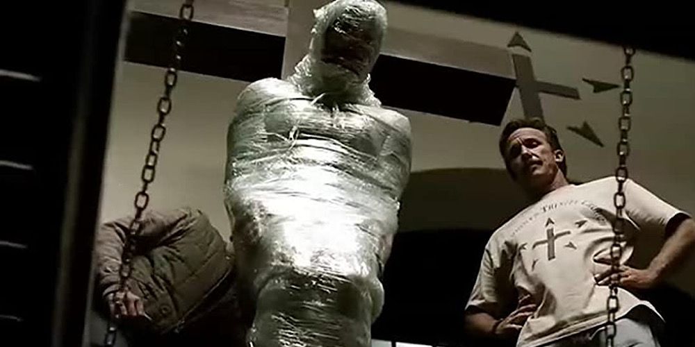 A man is chained up and covered in cling film in Red State
