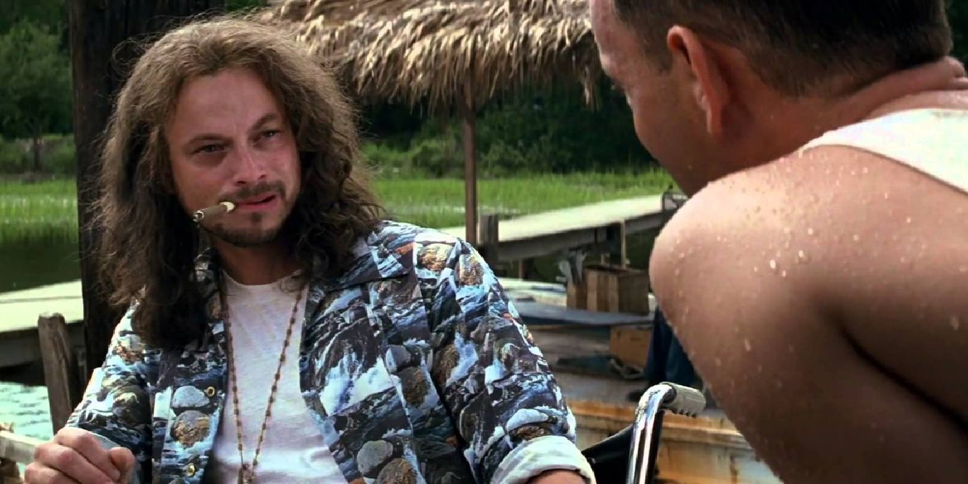 Gary Sinise como el teniente Dan hablando con Tom Hanks como Forrest mientras sostiene un cigarro en la boca en Forrest Gump.