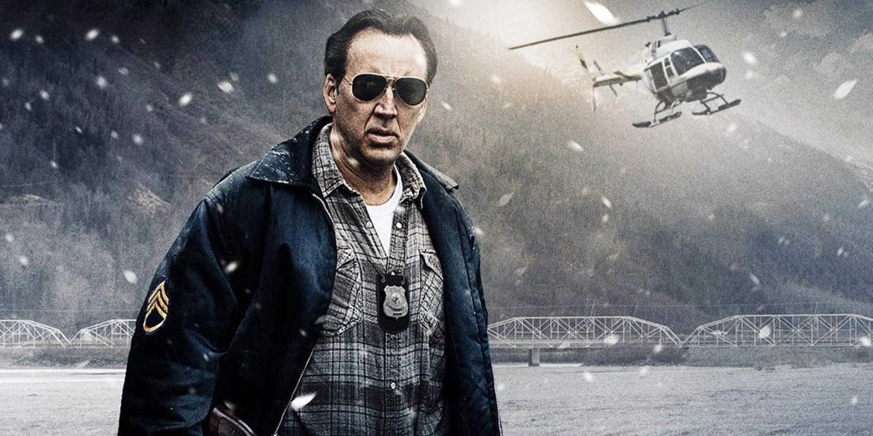 Nicolas Cage looks at the camera as a helicopter flies behind him in The Frozen Ground.