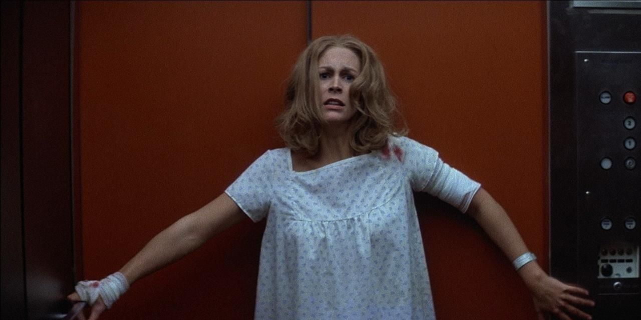 Laurie Strode stands against an elevator looking terrified in Halloween 2fi