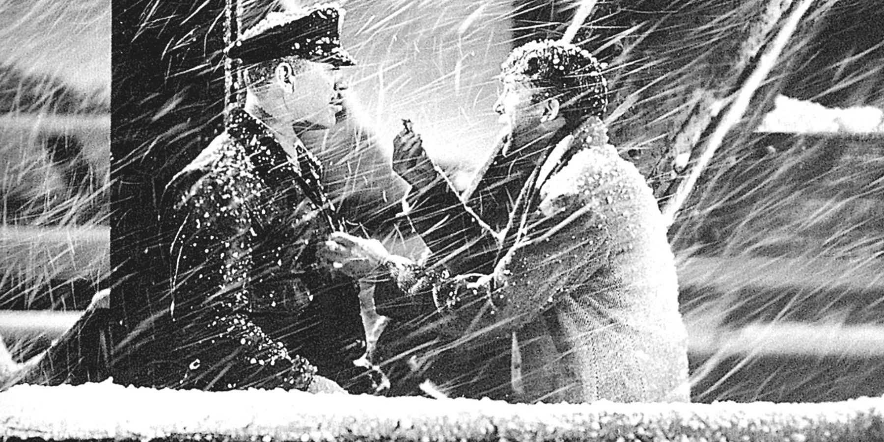 George Bailey gives something to a cop on a snowy night in It's a Wonderful Life.
