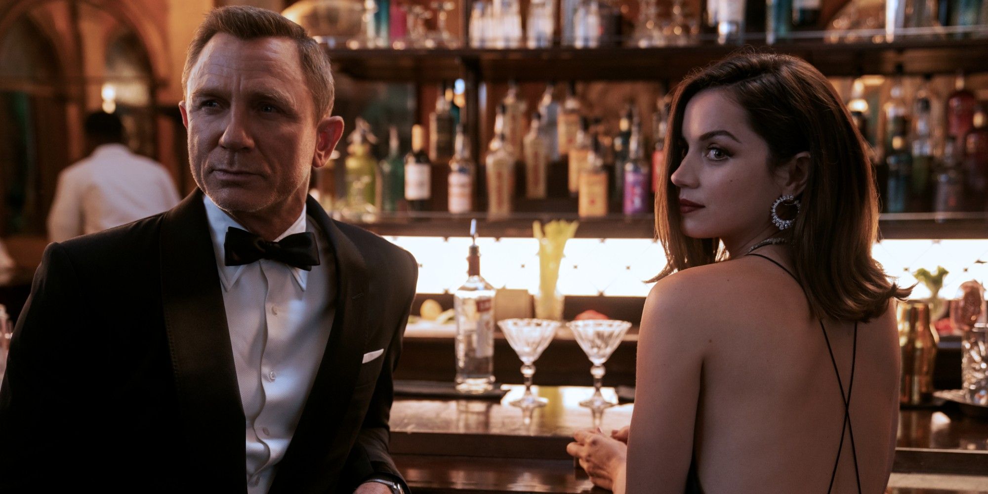 Daniel Craig and Ana de Armas standing at a bar in No Time to Die