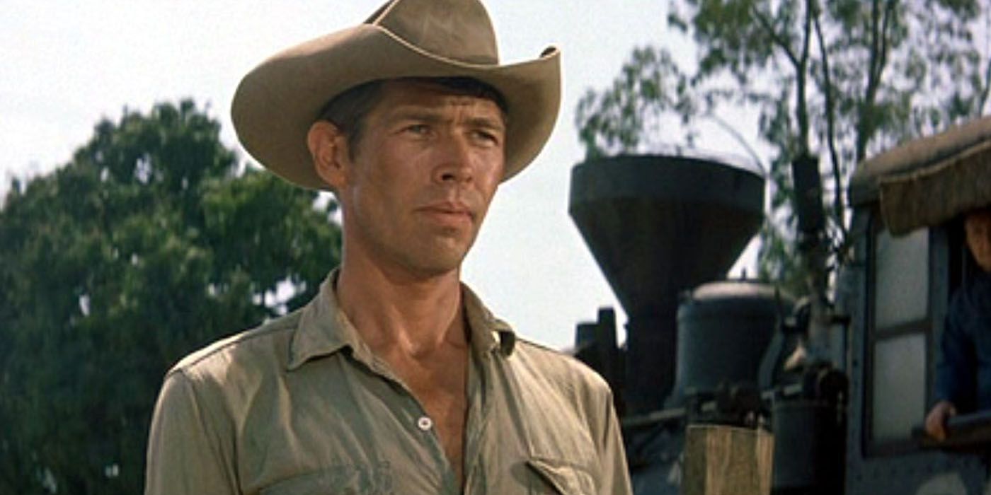James Coburn mengenakan topi koboi di luar The Magnificent Seven.