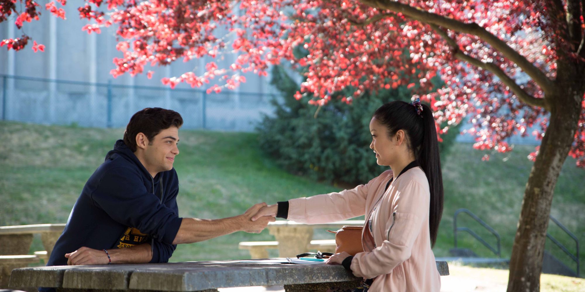 Lana Condor and Noah Centineo in To All the Boys I've Loved Before sitting under a sakura tree
