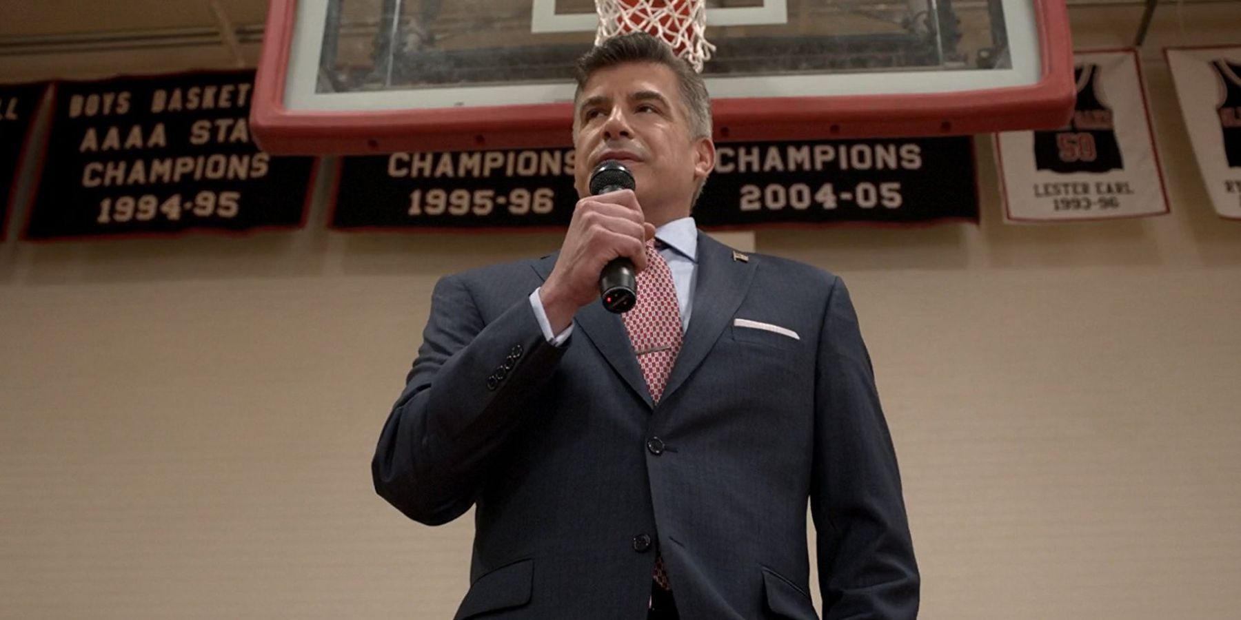 Mayor Maddox speaks into a microphone in a gym in the TV show Scream.