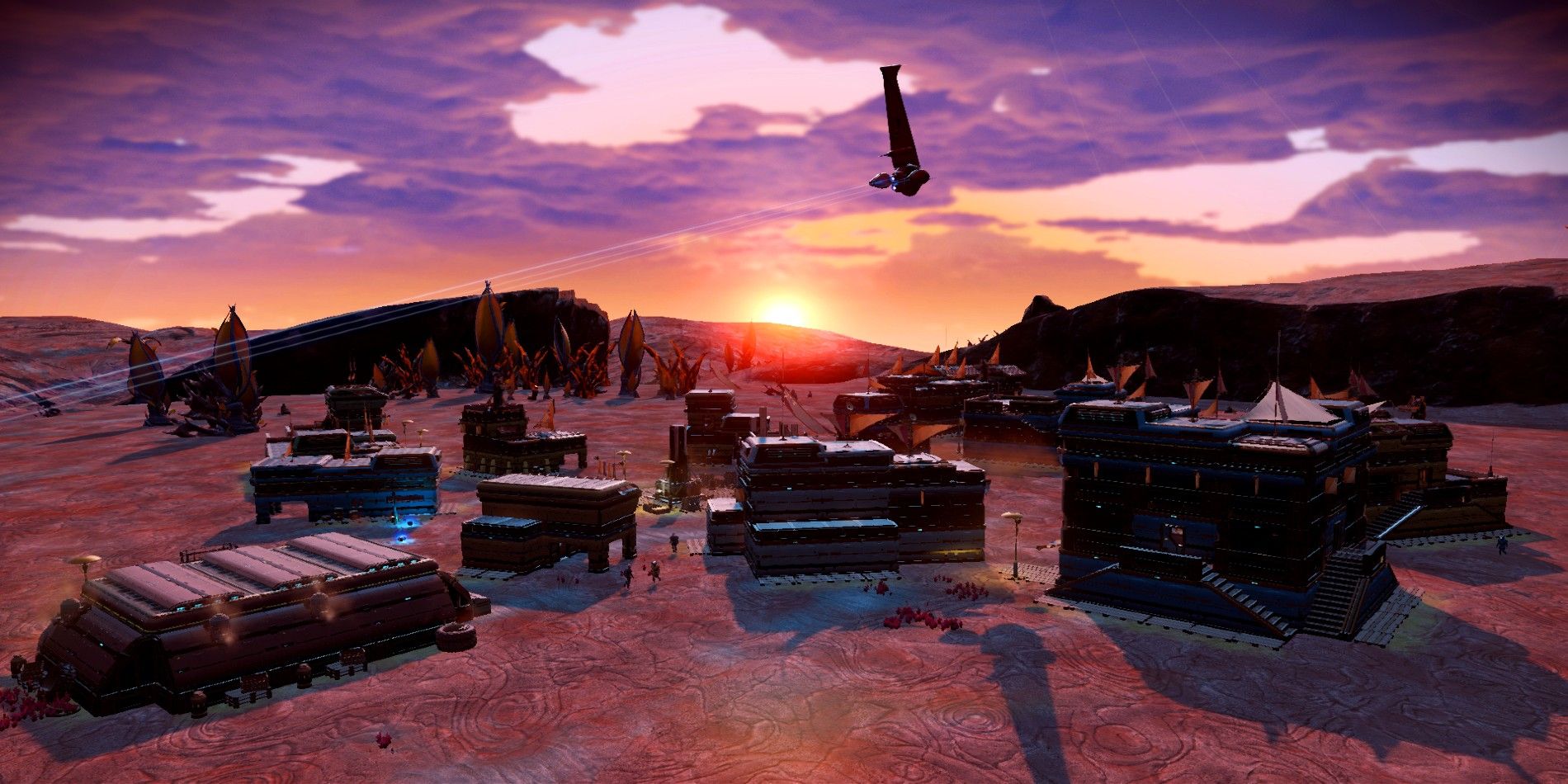 A settlement in No Man's Sky at sunset with a large ship hovering in the background