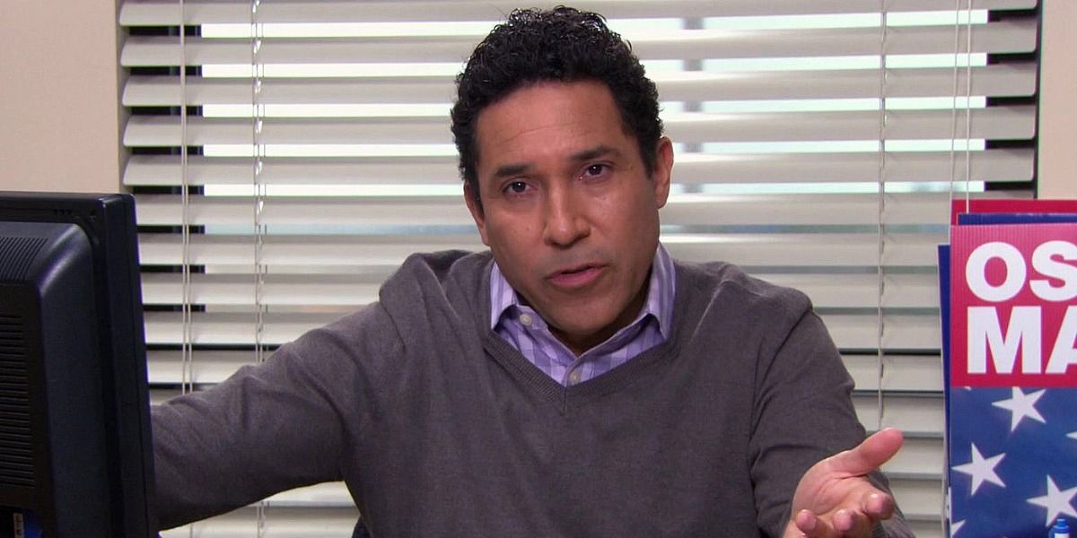 Oscar Martinez from The Office sat in an office with election posters behind him