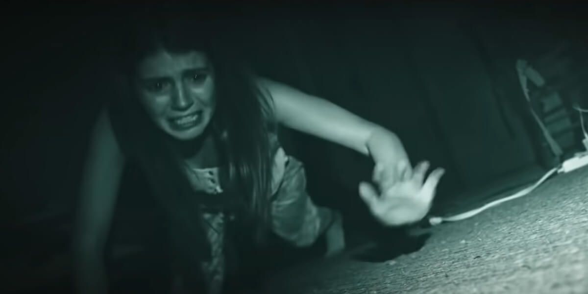 A sacred woman crawls on the floor in Paranormal Activity Next of Kin 