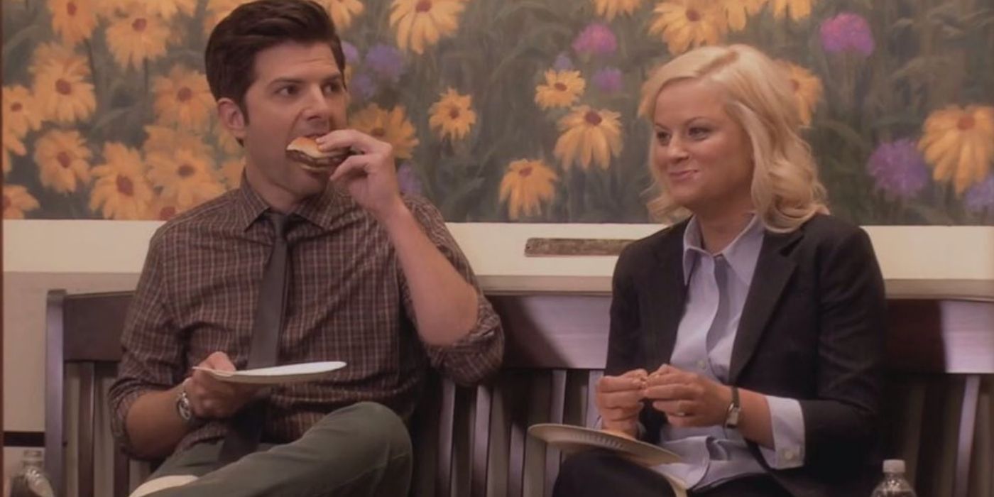 Ben and Leslie eating lunch in front of the wallflower mural in Parks and Recreation.