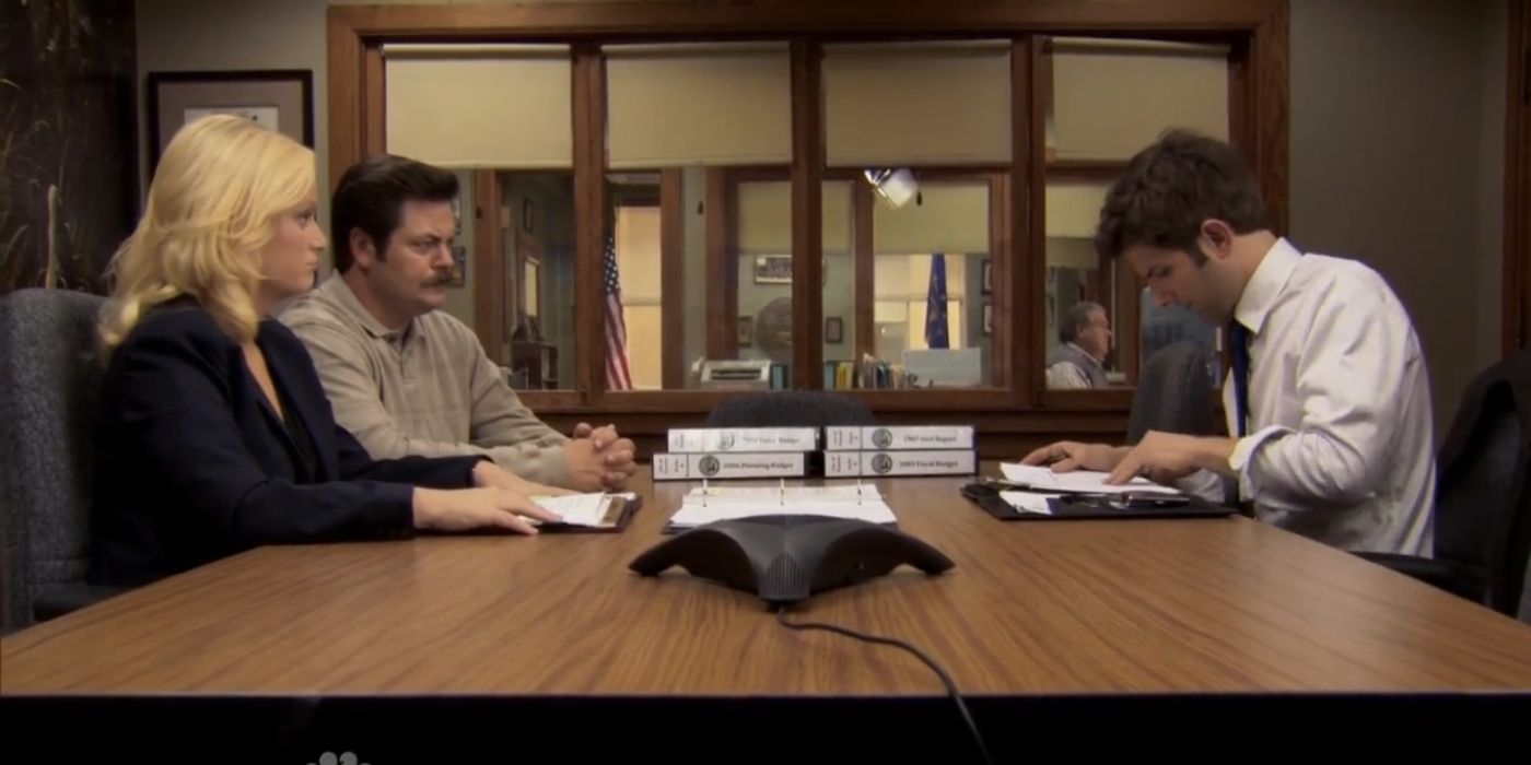Leslie, Ben, and Ron going over some figures in Parks and Recreation.