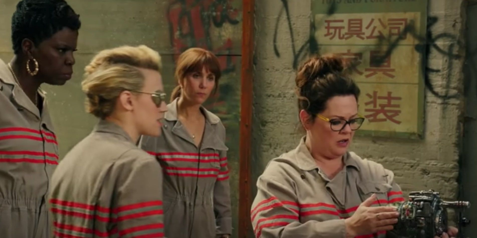 Abby Yates checks out Jillian Holtzmann's Proton Glove whilst the other Ghostbusters gather round
