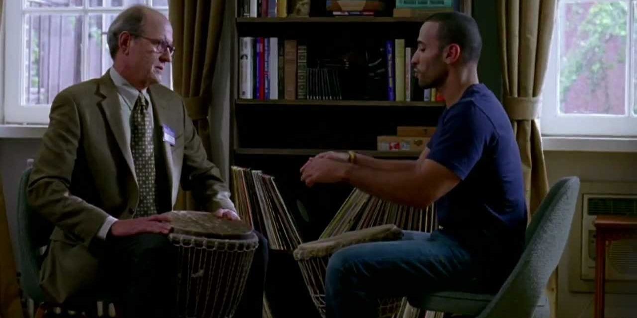 Richard Jenkins sitting and playing a drum with Haaz Sleiman in The Visitor