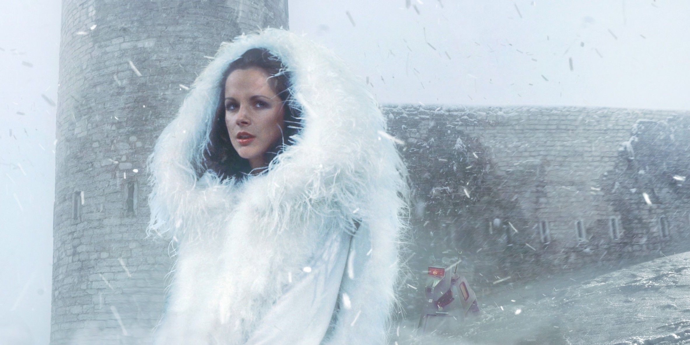 An image of Doctor Who's Romana I standing in a snowy landscape while wearing a large fur coat. K-9 is in the background.