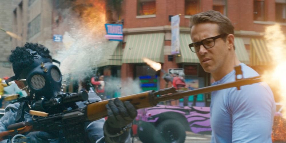 Ryan Reynolds stares at a masked man shooting a rifle in Free Guy